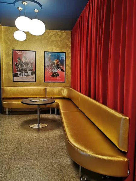 Elokuvateatteri Killan aulatilat virittävät kävijän tunnelmaan, jossa 1950-luvun glamour ja pehmeä ylellisyys kulkevat rinnakkain ja kullan väriset pehmeälinjaiset Palad sohvat ovat osana luomassa ylellistä tunnelmaa. | The lobby of Cinema Killa, where 1950s glamour meets soft elegance, sets the mood for visitors and the curved golden Palad sofas greate a glamorous atmosphere.